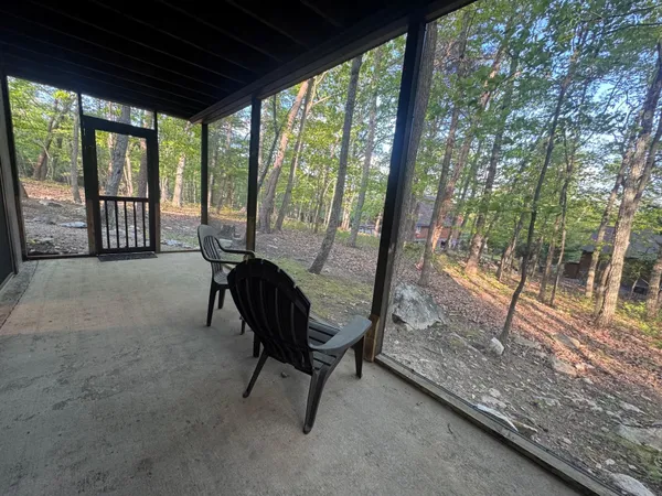 a view of a porch with chairs and backyard
