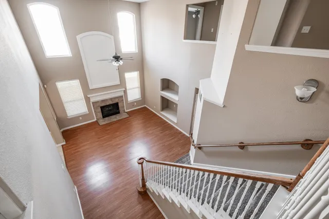 a view of a hallway with wooden floor and staircase