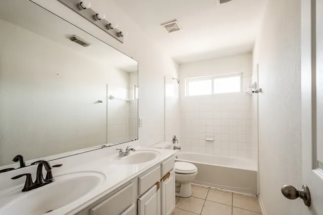 a bathroom with a granite countertop sink a toilet and shower