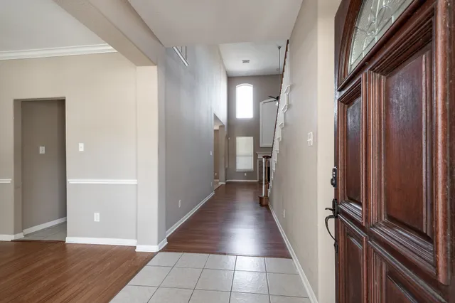 a view of a hallway with wooden floor and staircase