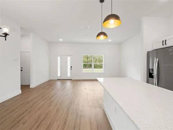 a view of a kitchen with wooden floor and a window