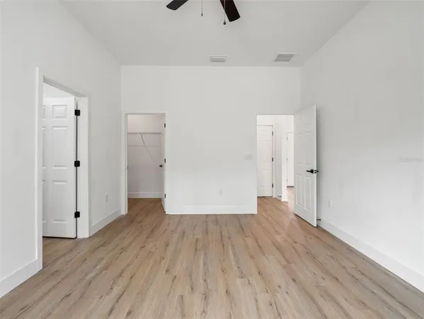 a view of a room with wooden floor and a ceiling fan