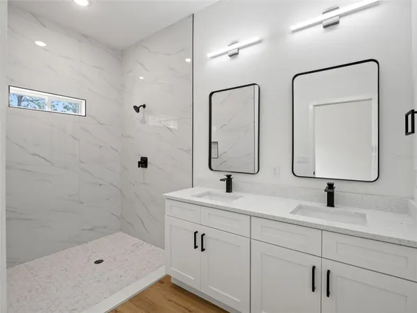 a bathroom with a double vanity sink mirror double and shower