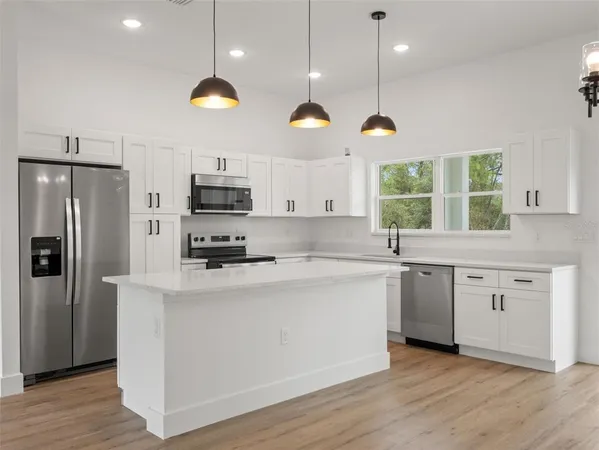 a kitchen with stainless steel appliances granite countertop a stove a sink and a refrigerator