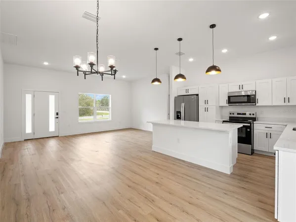 a view of a kitchen with stove and wooden floor
