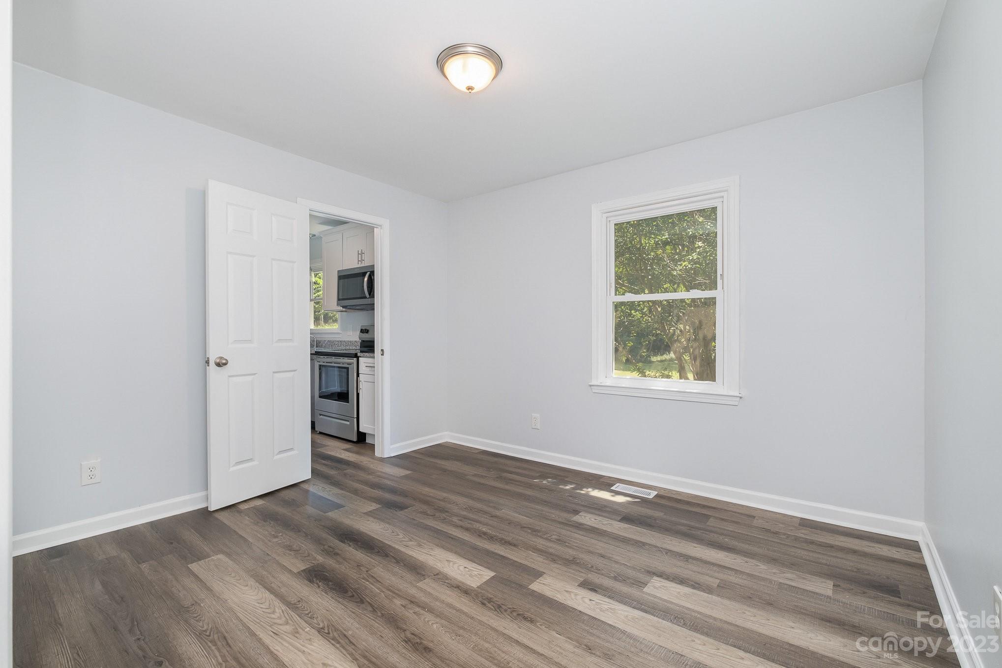 6364 Monteith Drive Charlotte, NC 28213 - Photo 11 of 35 an empty room with wooden floor cabinet and windows