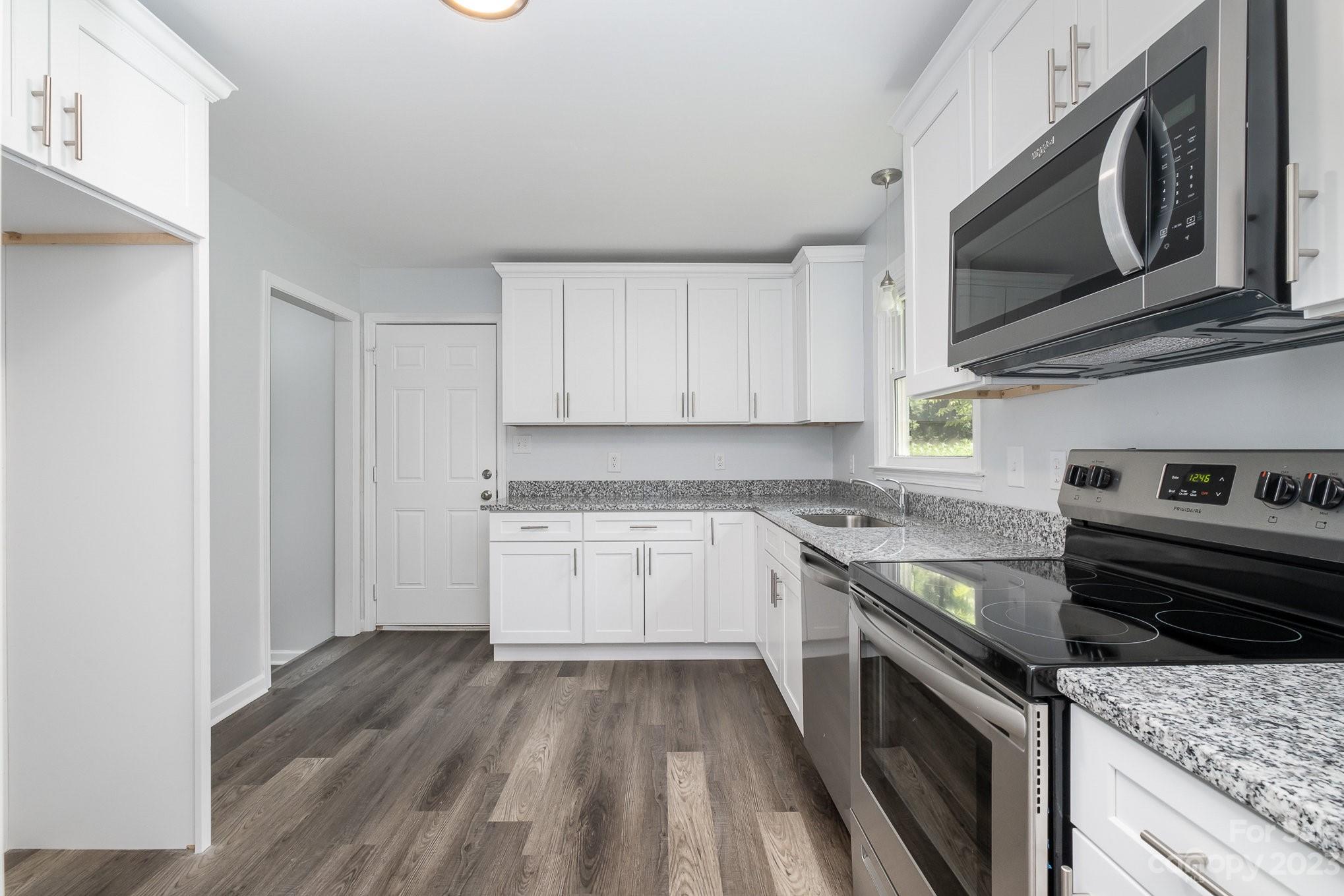 6364 Monteith Drive Charlotte, NC 28213 - Photo 14 of 35 a kitchen with granite countertop wooden cabinets stove top oven and sink