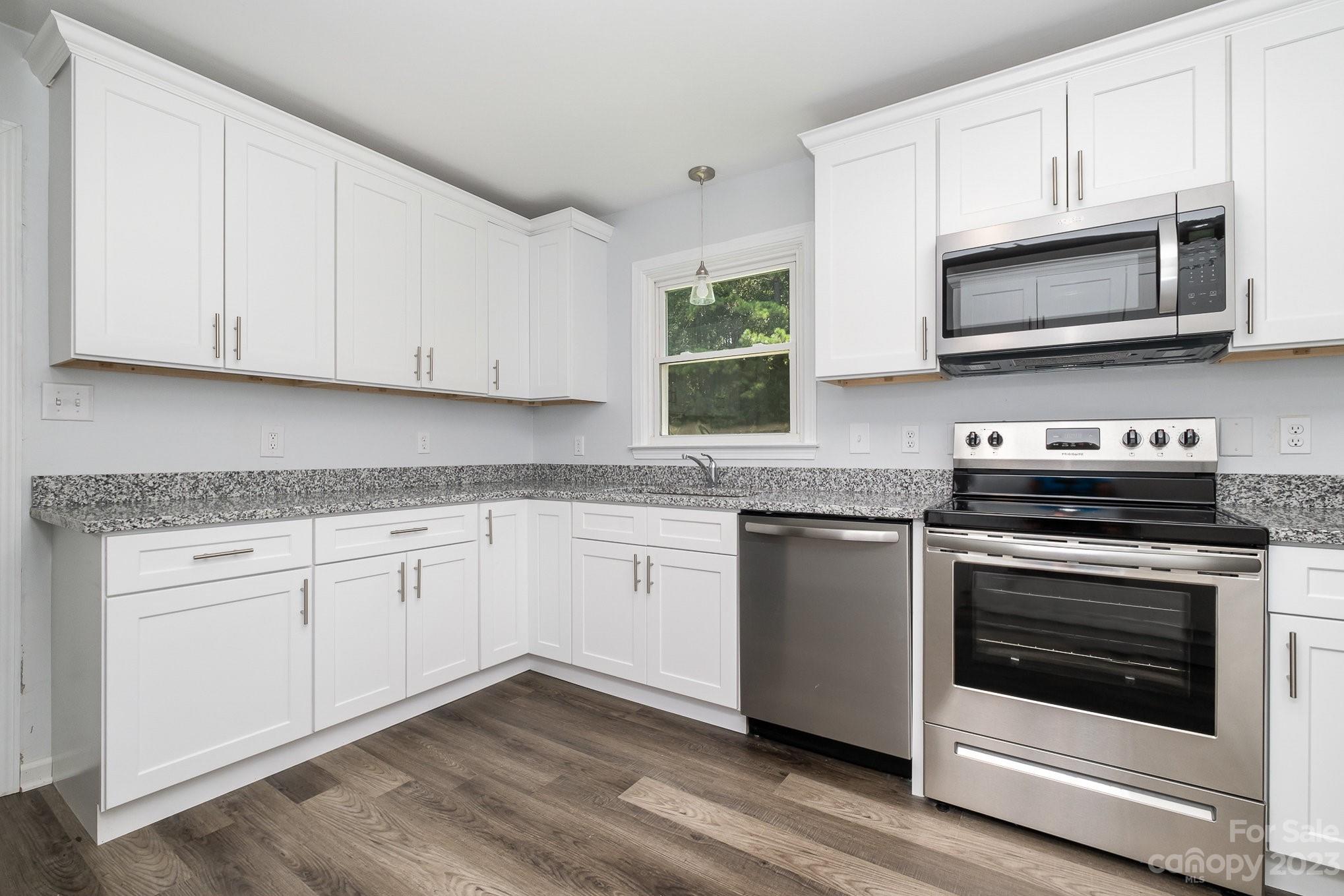 6364 Monteith Drive Charlotte, NC 28213 - Photo 17 of 35 a kitchen with granite countertop white cabinets stove and oven