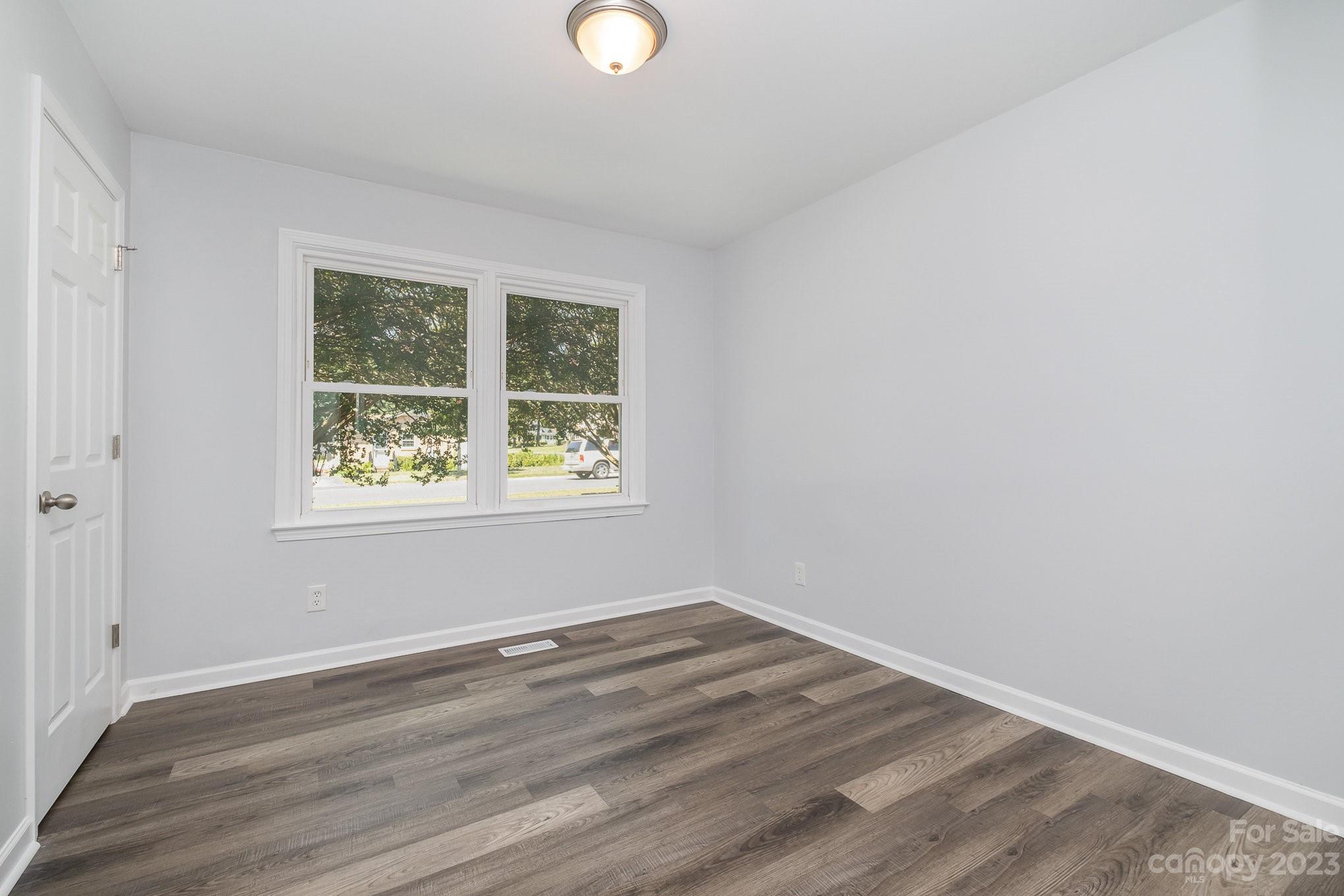 6364 Monteith Drive Charlotte, NC 28213 - Photo 25 of 35 an empty room with wooden floor and windows