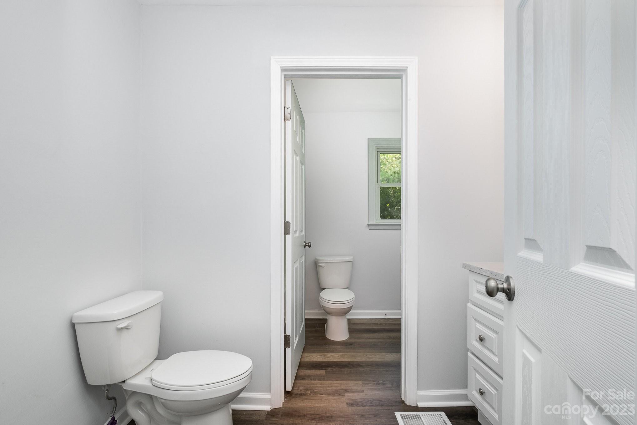 6364 Monteith Drive Charlotte, NC 28213 - Photo 30 of 35 a white toilet sitting next to a bathroom sink and vanity