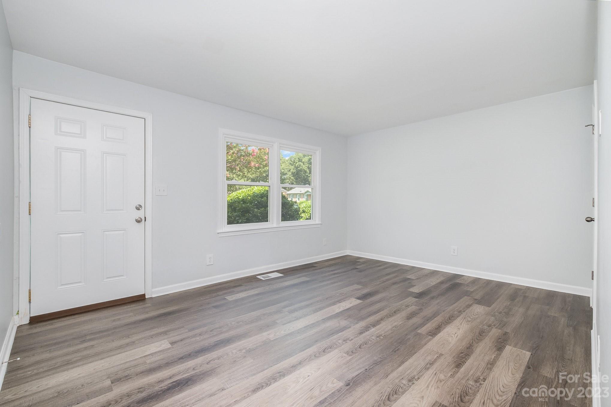 6364 Monteith Drive Charlotte, NC 28213 - Photo 9 of 35 an empty room with wooden floor and windows