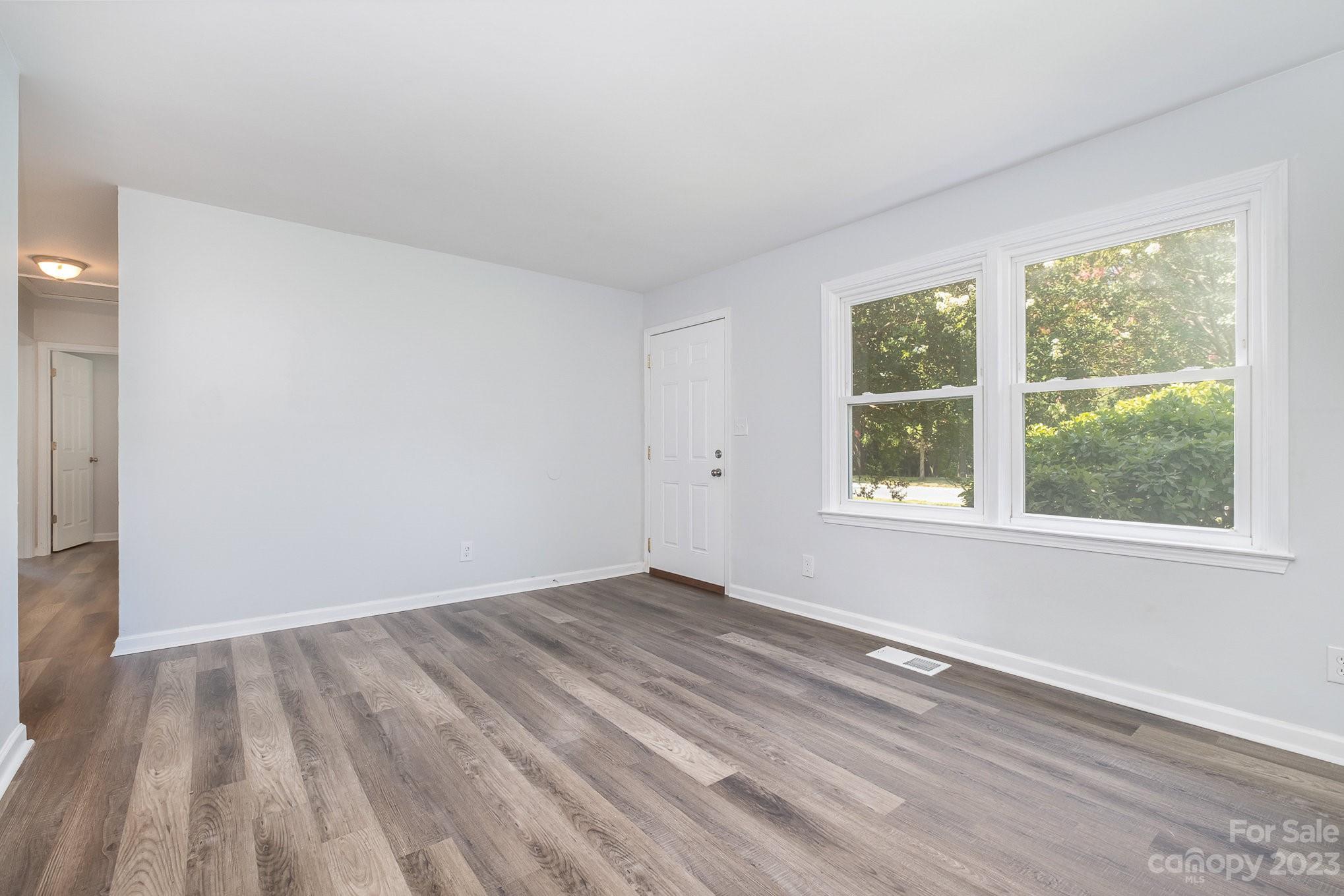 6364 Monteith Drive Charlotte, NC 28213 - Photo 10 of 35 an empty room with wooden floor and windows