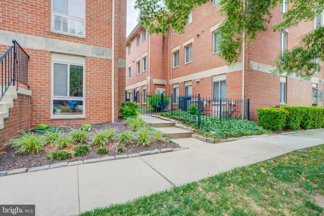 front view of a house with a yard and potted plants