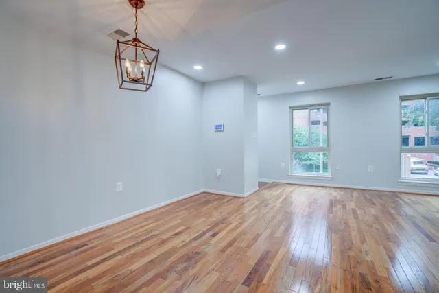 a view of empty room with wooden floor and window