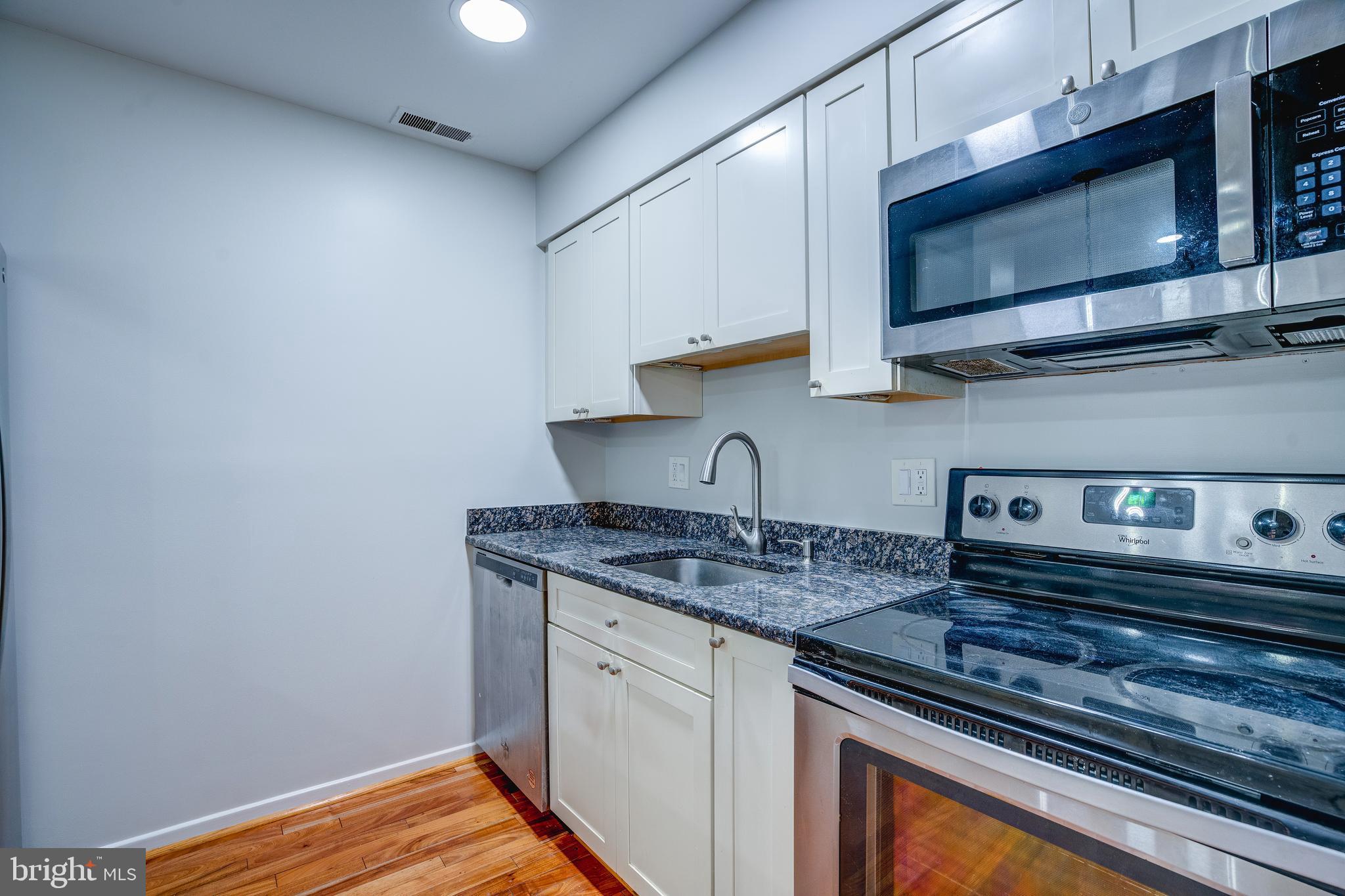 506 South Charles Street, Unit R92 Baltimore, MD 21201 - Photo 8 of 25 a kitchen with stainless steel appliances granite countertop a sink stove and microwave