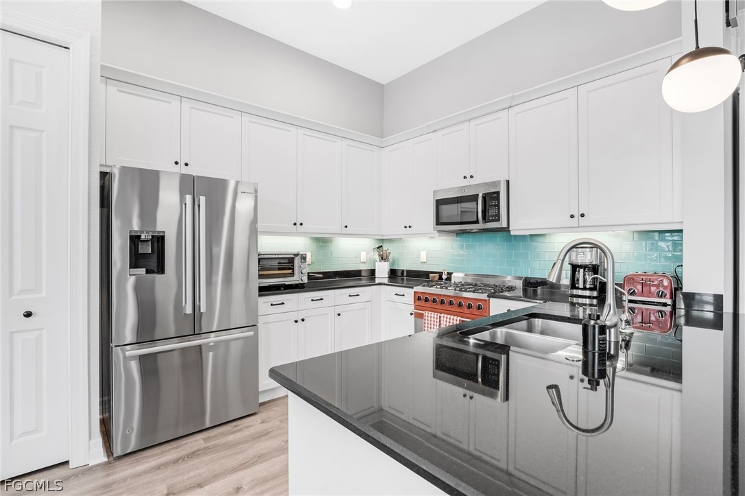 2999 Willow Ridge Court Fort Myers, FL 33905 - Photo 8 of 50 a kitchen with stainless steel appliances a refrigerator sink and white cabinets