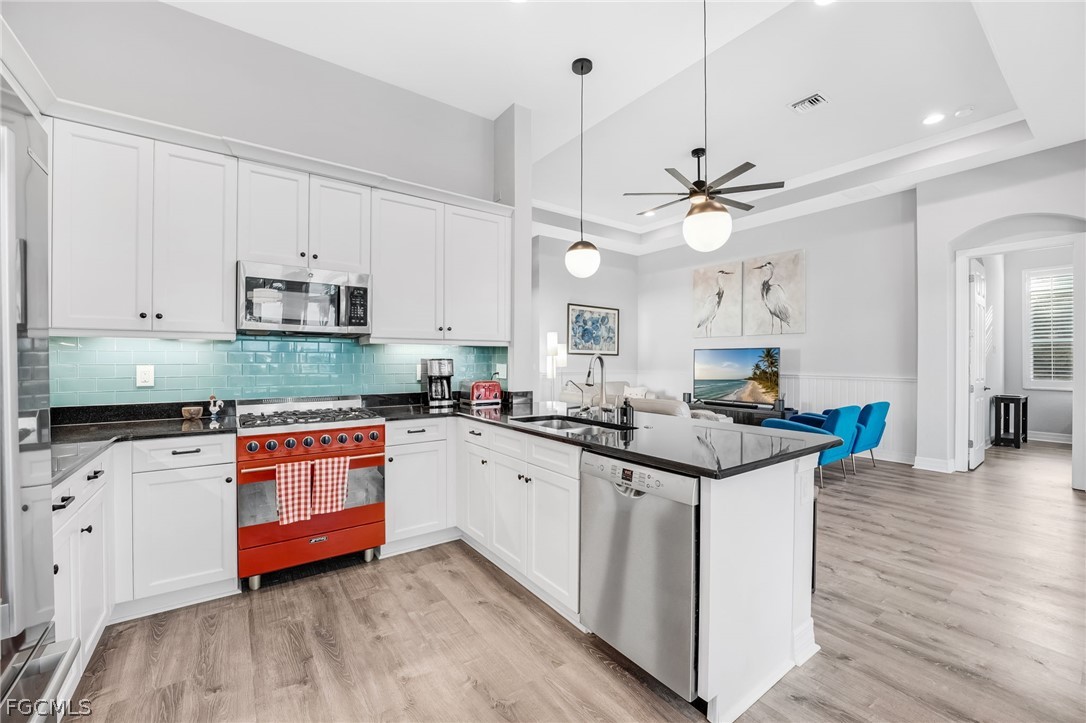 2999 Willow Ridge Court Fort Myers, FL 33905 - Photo 9 of 50 a kitchen with stainless steel appliances granite countertop a sink and stove a refrigerator with white cabinets
