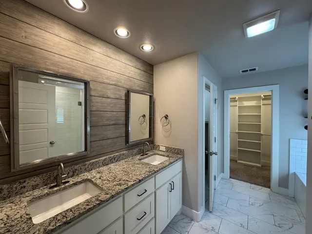 a bathroom with a granite countertop sink and a mirror