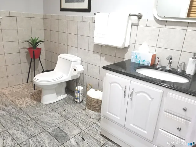 a bathroom with a granite countertop toilet and a sink