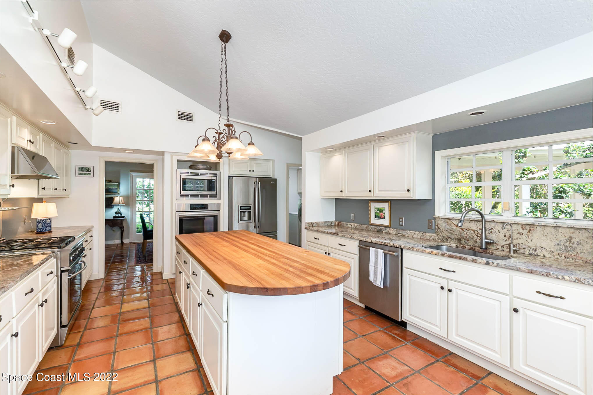 4025 Turtle Mound Road Melbourne, FL 32934 - Photo 13 of 54 a kitchen with stainless steel appliances kitchen island granite countertop a sink stove and refrigerator