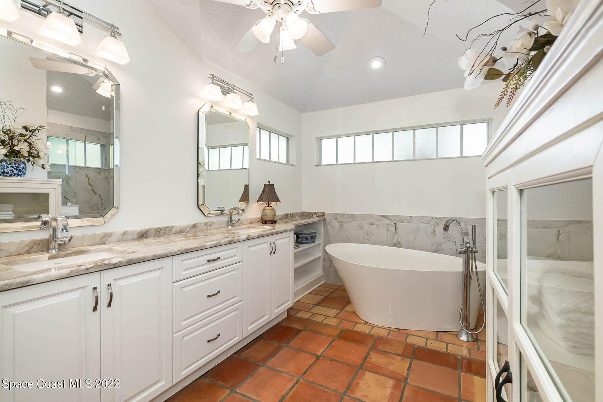 4025 Turtle Mound Road Melbourne, FL 32934 - Photo 34 of 54 a spacious bathroom with a double vanity sink a mirror and a bathtub