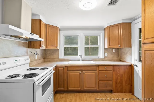 a kitchen with a sink a stove and cabinets