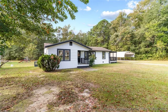 a view of a house with yard and sitting area