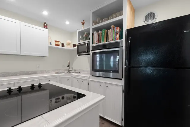 a kitchen with a sink a stove and cabinets