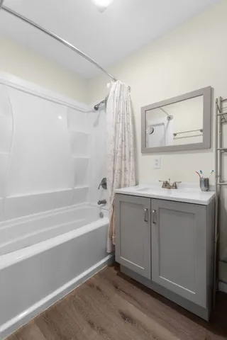 a bathroom with a tub sink a mirror and a shower