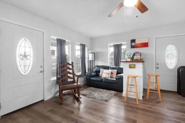 a living room with furniture a rug and wooden floor