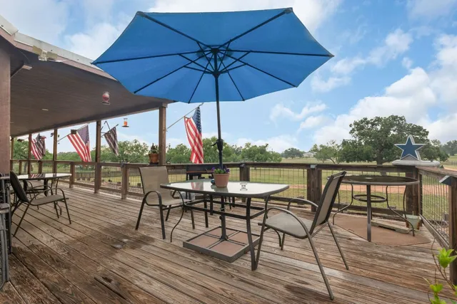 a view of a terrace with furniture and umbrella