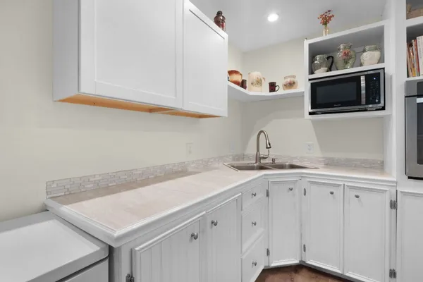 a kitchen with stainless steel appliances white cabinets and a sink
