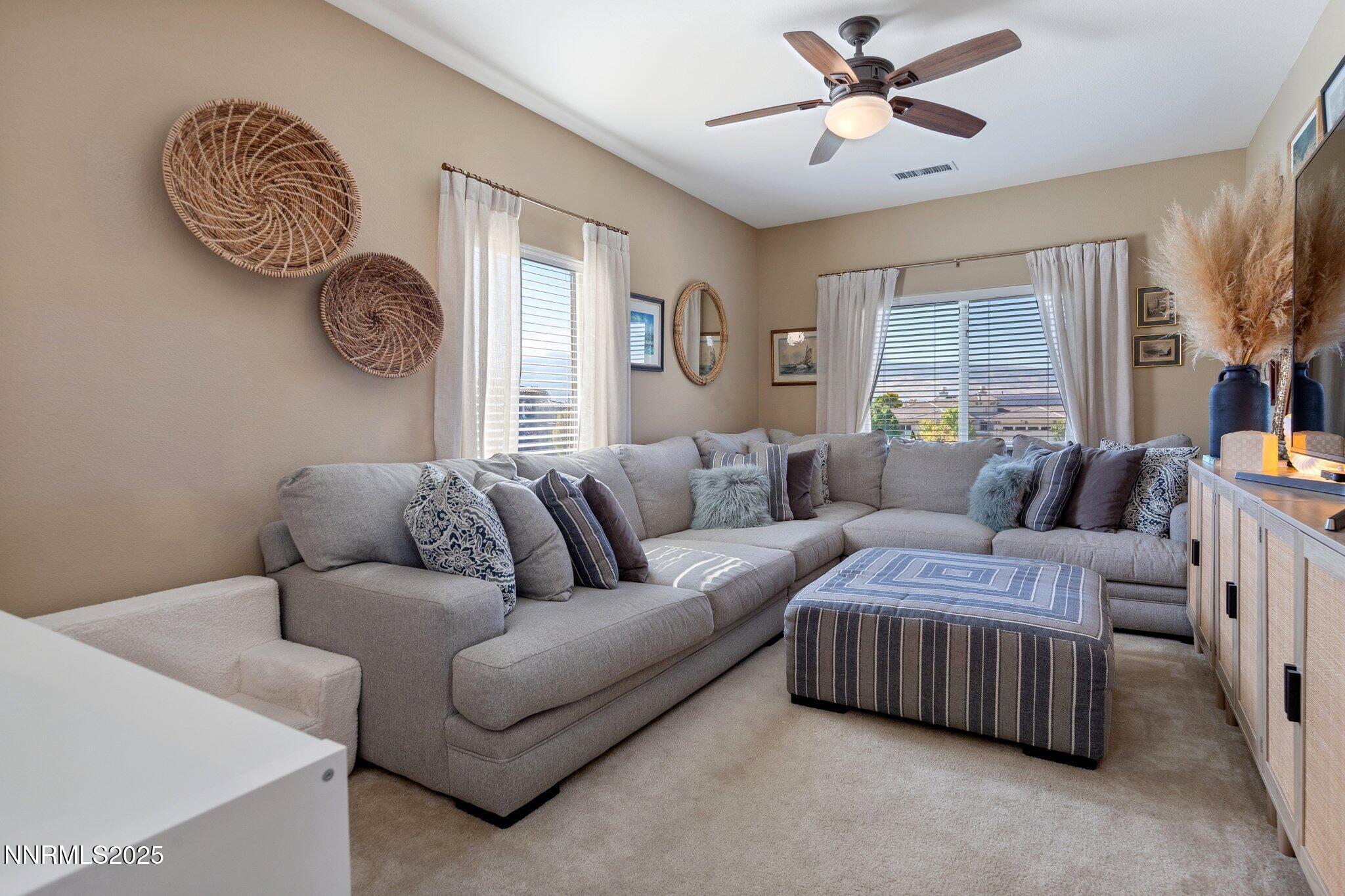 9845 Copenhagen Way Reno, NV 89521 - Photo 20 of 57 a living room with a couch and a chandelier