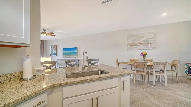 a group of people sitting on a kitchen counter top a dining table and chandelier