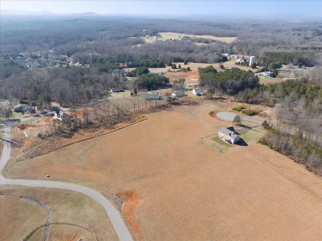 an aerial view of a house with a yard and ocean view