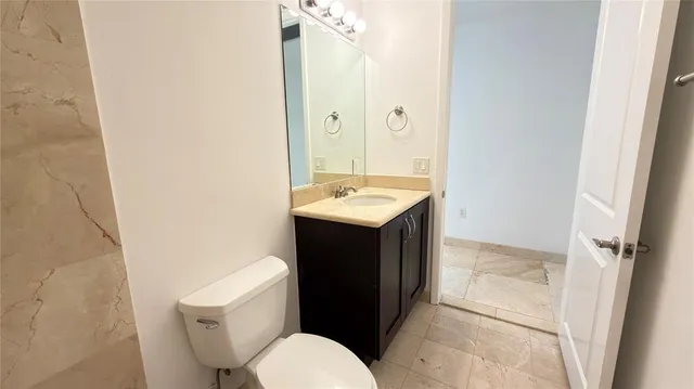a view of a hallway with wooden floor and a potted plant