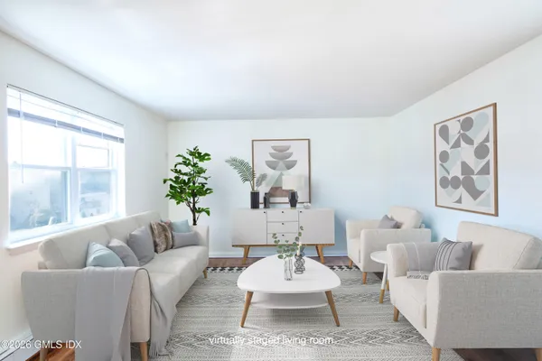 a living room with furniture potted plant and window