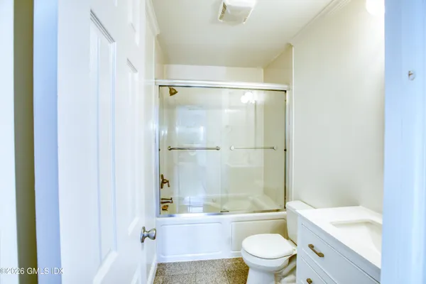 a bathroom with a bathtub shower sink mirror and toilet