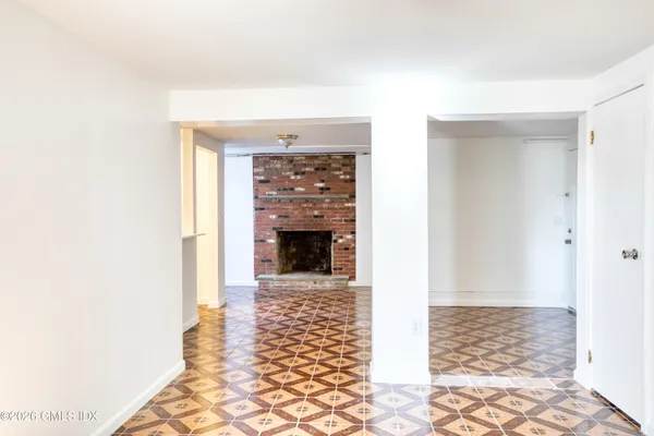 a view of a hallway with wooden floor and a fireplace