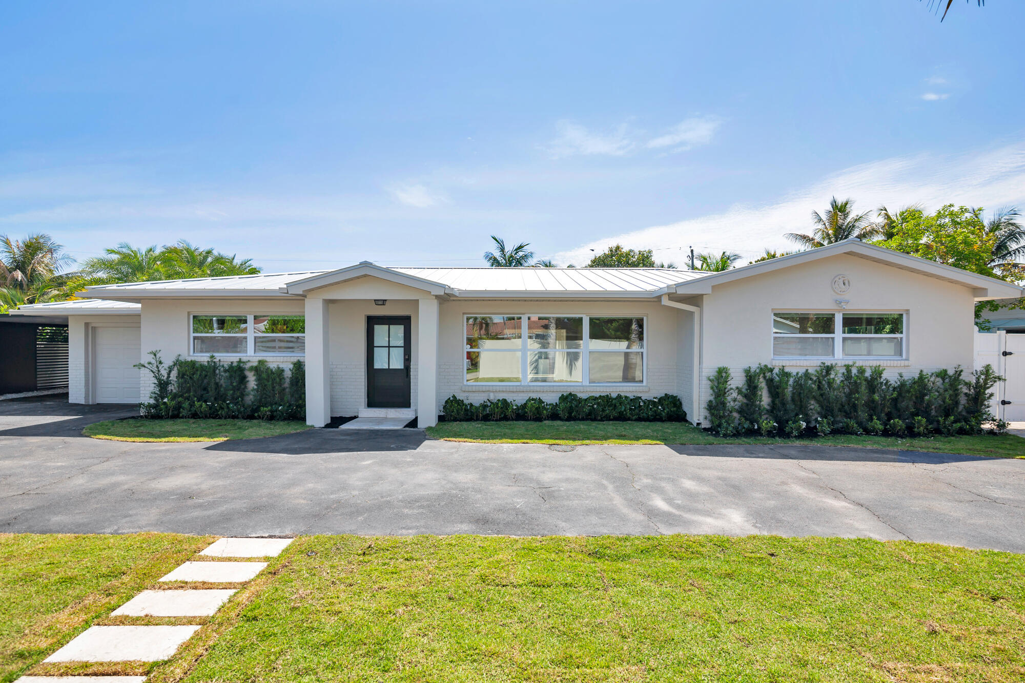 7320 Clarke Road West Palm Beach, FL 33406 - Photo 1 of 38 a front view of a house with a yard and potted plants