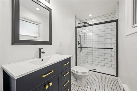 a bathroom with a granite countertop toilet a sink and a mirror