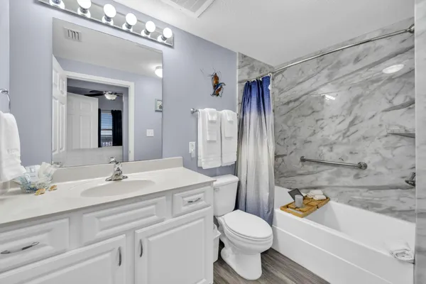 a bathroom with a sink a toilet a mirror a bathtub and shower