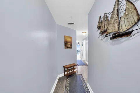 a view of a hallway with wooden floor and staircase