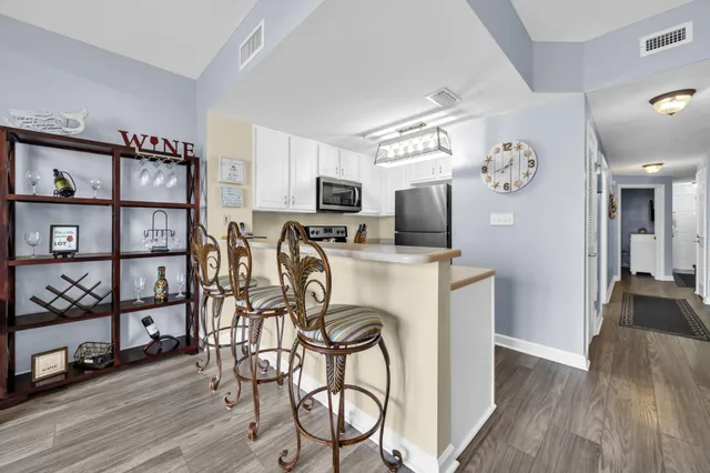 a view of a kitchen with fridge and wooden floor