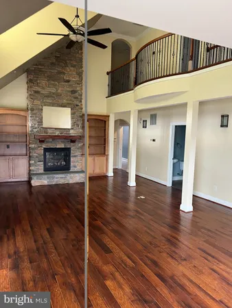 a view of a livingroom with wooden floor and a ceiling fan