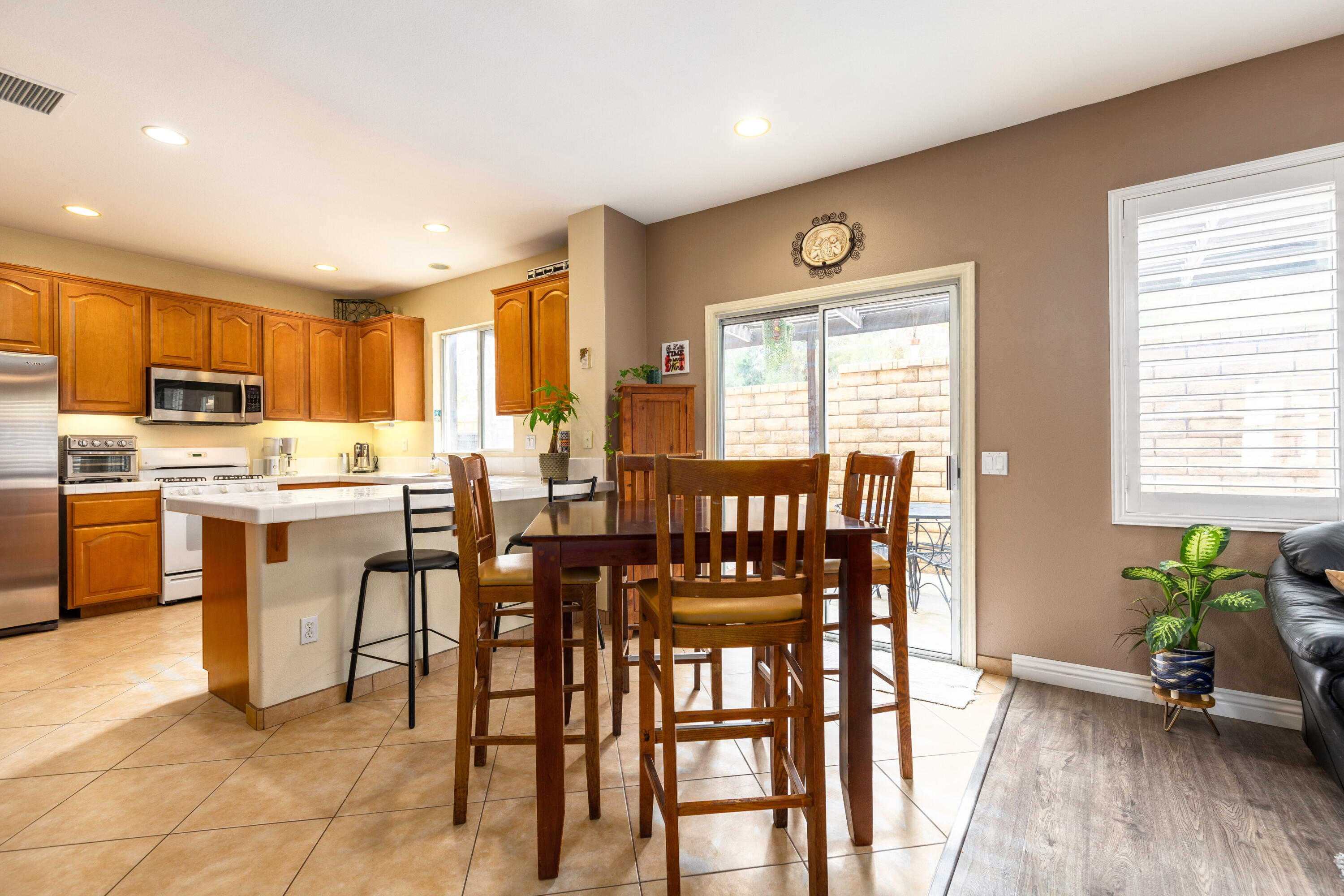 28341 Willow Court Saugus, CA 91350 - Photo 11 of 23 a open dining room with stainless steel appliances a table chairs and a refrigerator