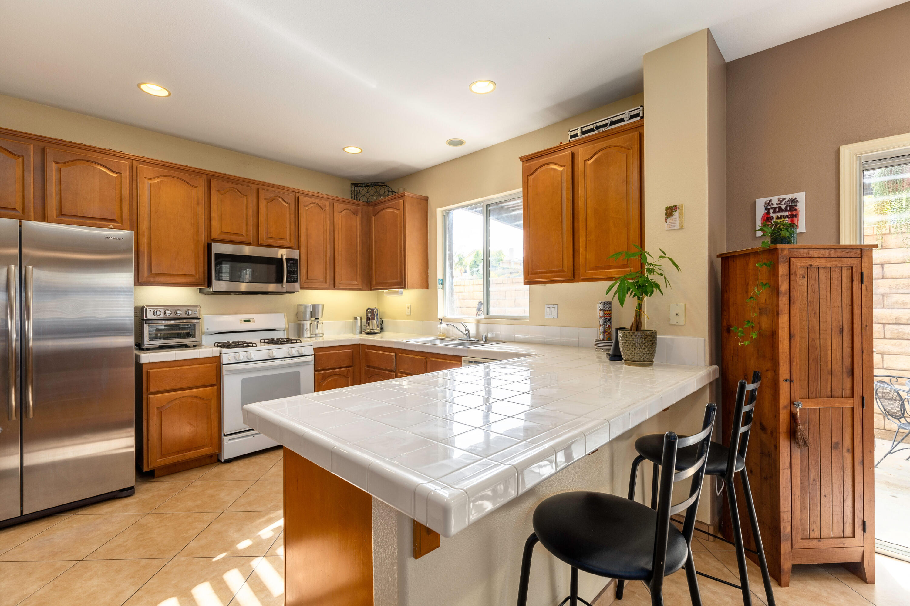 28341 Willow Court Saugus, CA 91350 - Photo 12 of 23 a kitchen with stainless steel appliances granite countertop a stove a refrigerator a sink a dining table and chairs