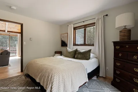 a bedroom with a bed and a lamp on dresser