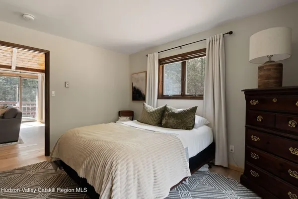 a bedroom with a bed and a lamp on dresser