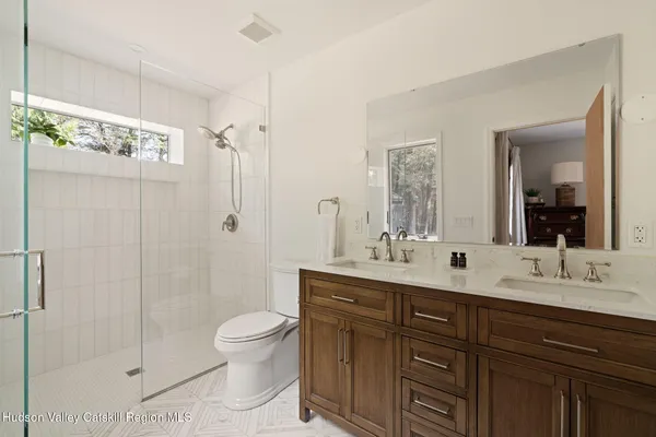 a bathroom with a double vanity sink toilet and shower